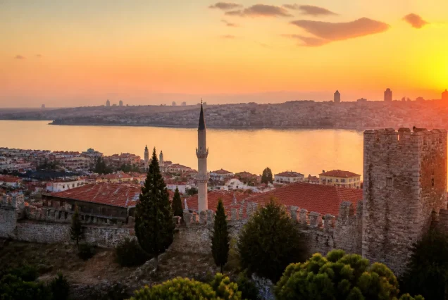 Balkanlar'da tarihi şehir merkezi ve nehir kıyısının gün batımında panoramik görünümü.
