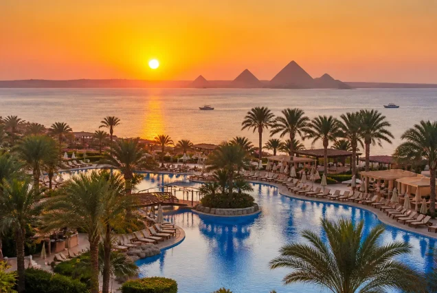 Kızıldeniz kıyısında gün batımı ve Giza Piramitleri manzarası
