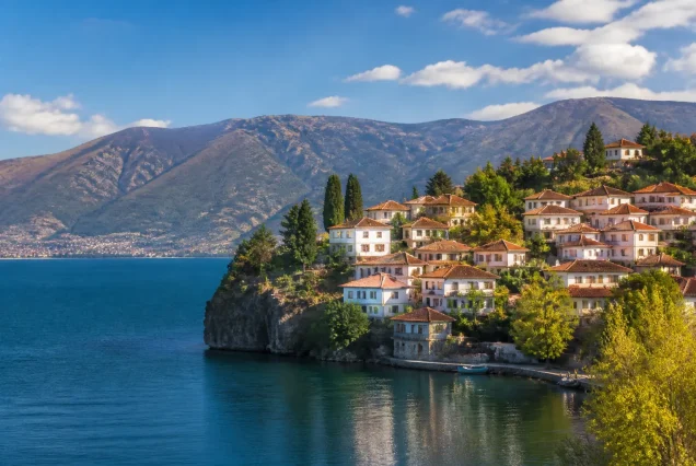 Balkanlar bölgesinde göl kıyısındaki tarihi evler ve çevresindeki doğal manzara