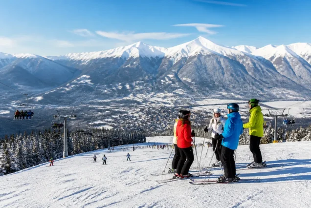 Bansko'da karlı dağlar ve kayak pistlerinde kayak yapan insanlar