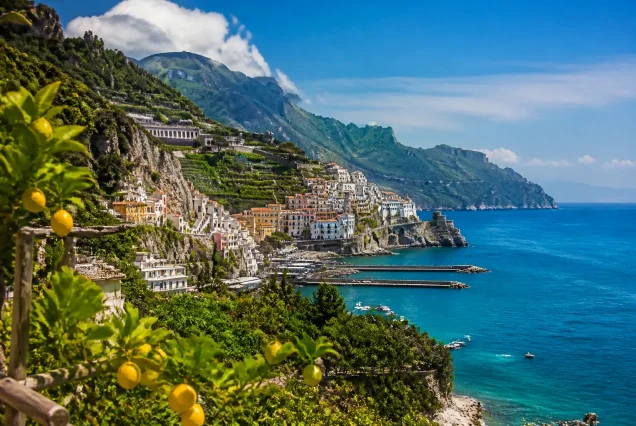 Amalfi Sahilleri'nin turkuaz deniz ve renkli evlerle çevrili sarp kayalıklar üzerindeki panoramik görüntüsü