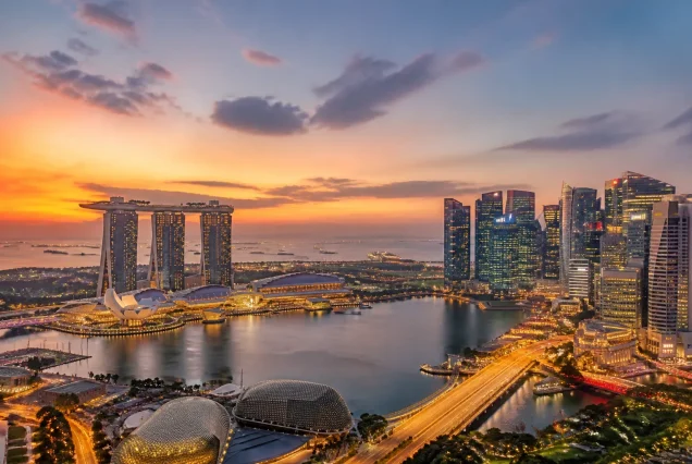 Singapur Marina Bay bölgesinde gün batımı manzarası ve şehir ışıkları