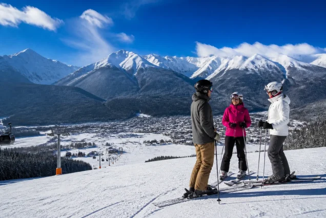 Bansko'da karlı dağlar ve kayak pistlerinde kayak yapan insanlar