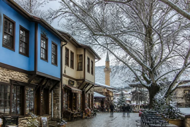 Karlarla kaplı Uludağ'da kayak yapan insanlar ve dağ manzarası